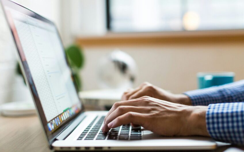 person typing on silver Macbook