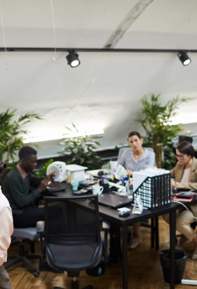 Team of professionals working together in a modern, plant-filled office space